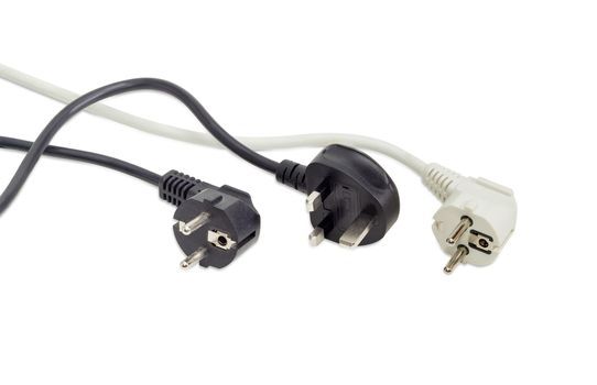 Black AC power plug of United Kingdom standard and one black and one white power plugs of combined German and French standard with fragment of a power cords on a light background
