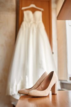 wedding shoes and bride in a bedroom.