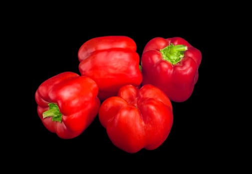 Several fresh red bell peppers on a dark background
