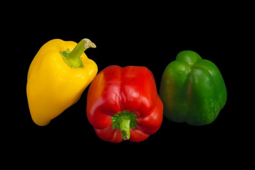 Fresh yellow, red and green bell peppers on a dark background
