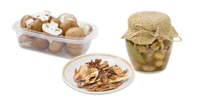 Dried boletus, pickled button mushrooms in glass jar, fresh uncooked button mushrooms in a transparent plastic tray on a light background