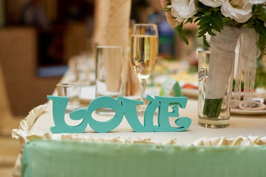 wooden letters love on wedding table bride and groom.