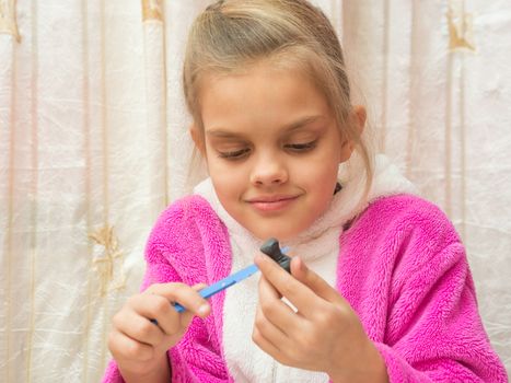 Seven-year girl on a stack makes drawing Crafts from clay