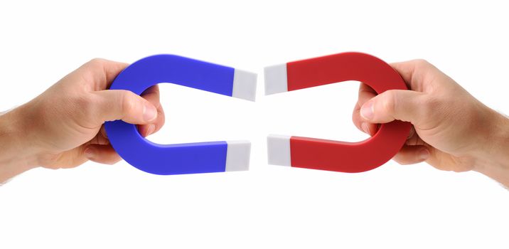 hands holding magnets one red and one blue isolated on a white background