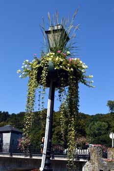 Bronze streetlight and glass with two flowerpots.