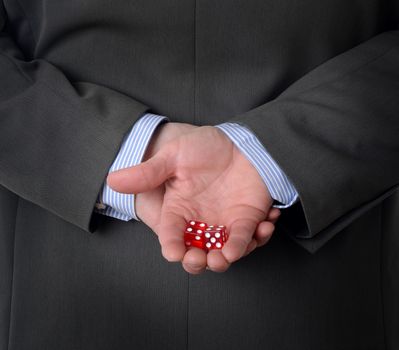Man in suit with dice behind his back