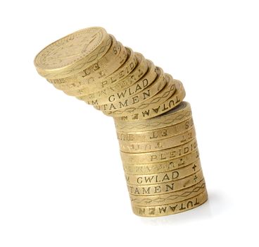 Stack on golden coins tipping over isolated on a white background