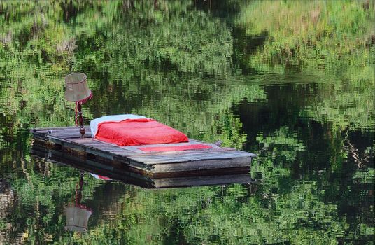 A double bed floating on a lake in the forest, perfect nights sleep