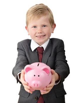Young boy in business suit holding out a piggybank isolated on a white background focus on the piggy bank.