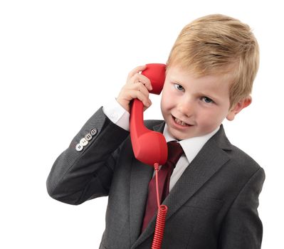 young boy in a suit talking on a red phone isolated on a white background
