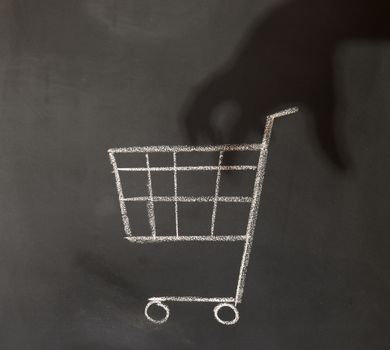 shadow of a hand reaching in to a shopping cart
