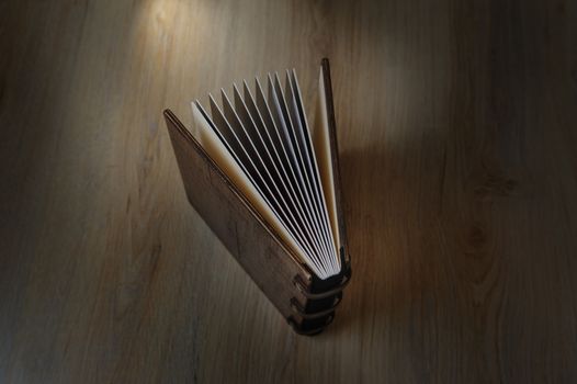 photobook disclosed on a wooden background with light