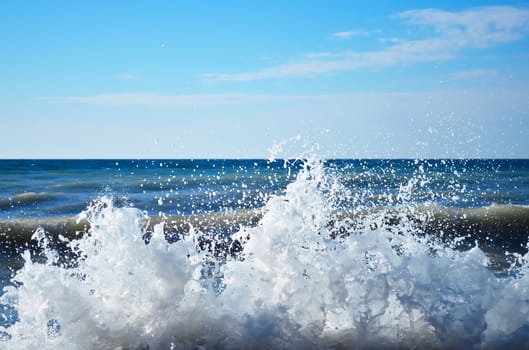 Powerful waves of the sea foaming, breaking against the rocky shore