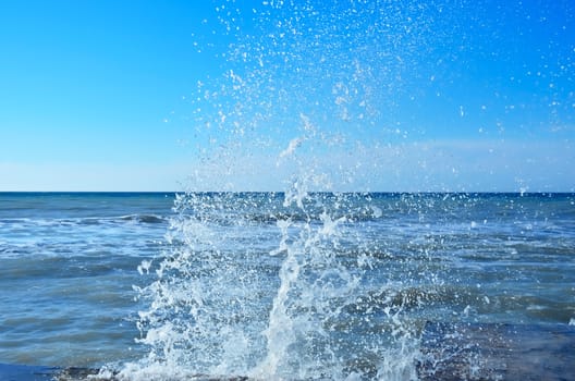 Powerful waves of the sea foam, breaking the concrete pier