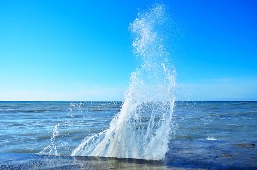 Powerful waves of the sea foam, breaking the concrete pier