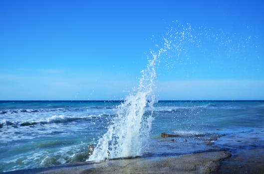 Powerful waves of the sea foam, breaking the concrete pier