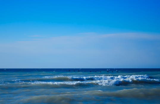 Powerful waves of the sea foaming, breaking against the rocky shore