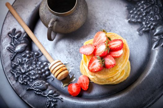 Stack of sweet pancakes with strawberry and honey. Gluten free flour.