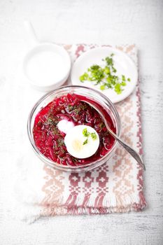 Bowl of beetroot soup with sour cream and eggs.