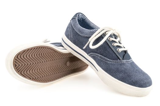 Picture of a pair of blue trainers over a white background. Selective focus.