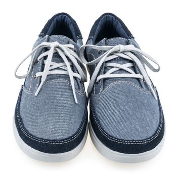 Picture of a pair of blue trainers over a white background. Selective focus.