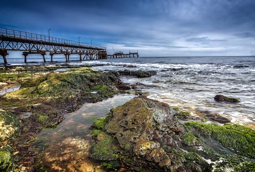 long exposure landscape with old broken bridge and rocky coast