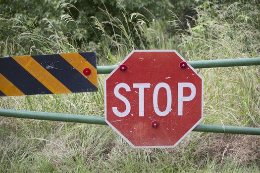 Stop sign on an open fence to a field