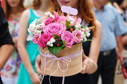 bridesmaid holding bridal bouquet on walk in summer park