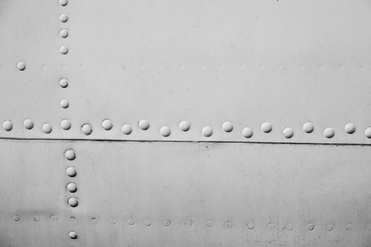 Aircraft metal plating texture with rivets background.