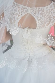 bride in white wedding dress turned her back close-up