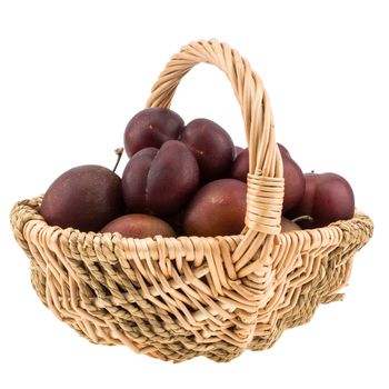 Sweet Plums in the wicker basket isolated on white background. Selective focus.