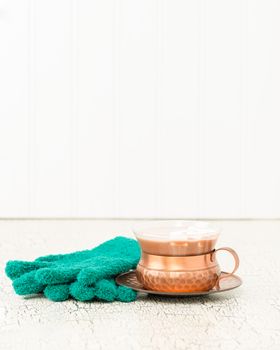 Creamy hot chocolate and a pair of green knitted gloves.