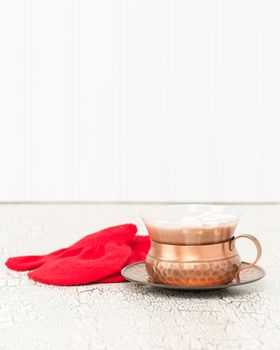 Creamy hot chocolate and a pair of red knitted mittens.