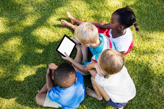 Kids using technology during a sunny day at park