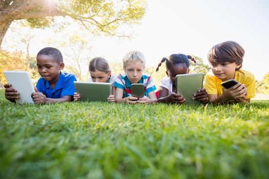 Kids using technology during a sunny day at park