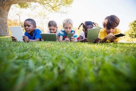 Kids using technology during a sunny day at park