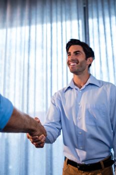 Two businessmen giving a handshake in the office