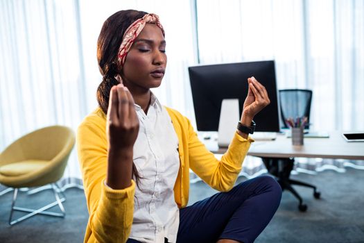 Close up of businesswoman doing yoga at the office