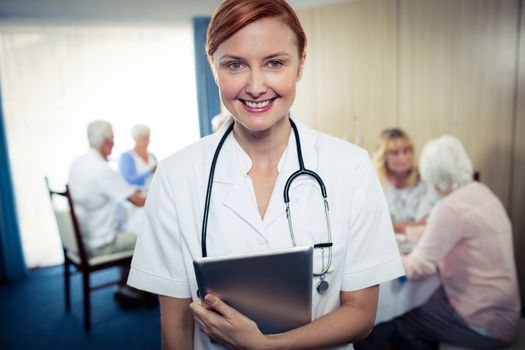 Portrait of a nurse with tablet computer in the retirement house