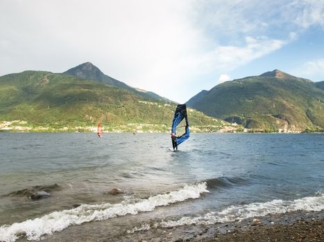 Cremia, Italy - September 5, 2015: Several windsurfing and kitesurfing with thermal wind from the south on Lake Como.