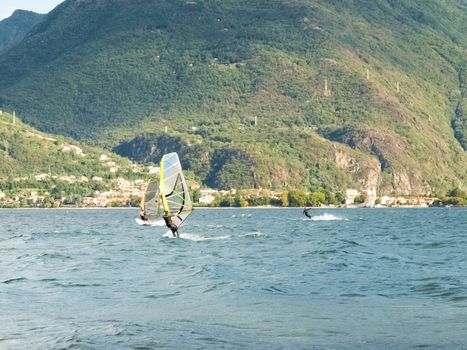 Cremia, Italy - September 5, 2015: Several windsurfing and kitesurfing with thermal wind from the south on Lake Como.