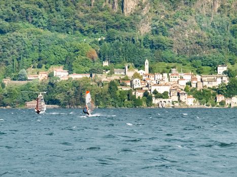 Cremia, Italy - September 5, 2015: Several windsurfing and kitesurfing with thermal wind from the south on Lake Como.