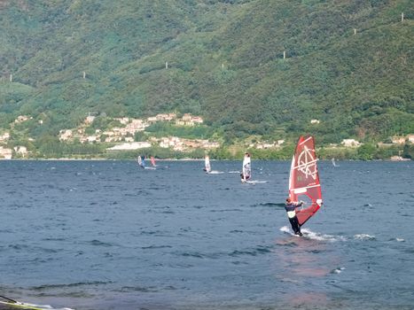 Cremia, Italy - September 5, 2015: Several windsurfing and kitesurfing with thermal wind from the south on Lake Como.