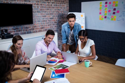 Manager leading a meeting with a group of creative designers in the office