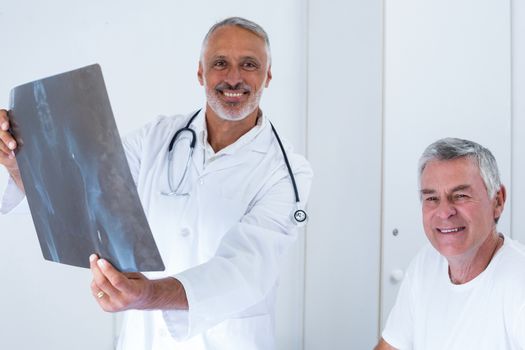Male doctor discussing x-ray with senior man in hospital