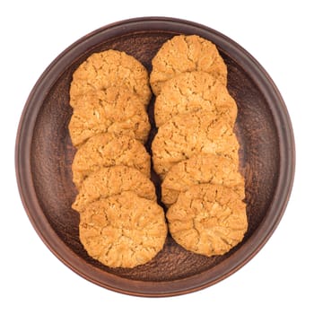 Oatmeal cookies in a brown plate. Isolated on white background. Top view.
