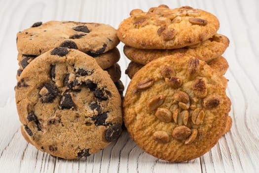 Biscuits with chocolate and peanut on old wooden table. Selective focus.