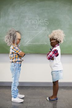 Kids wearing wig standing face to face in classroom at school