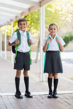 Portrait of smiling school kids standing in corridor at school