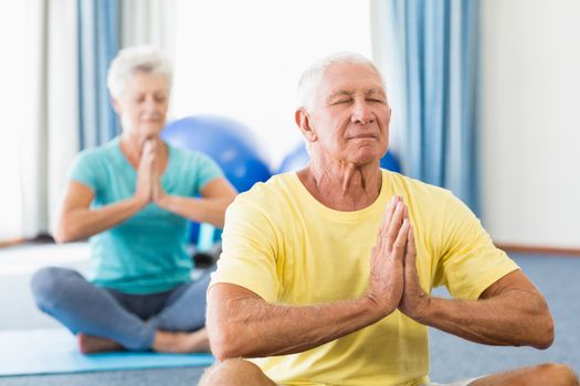 Seniors performing yoga in a studio